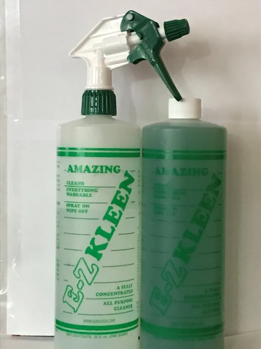 Two green E-Z KLEEN all-purpose cleaner bottles with spray nozzles. Labels emphasize concentration and washability features.
